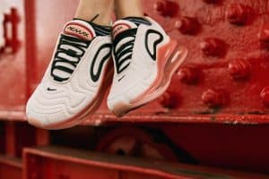 Pies de mujer luciendo unas zapatillas Nike blancas y rosas con plataforma